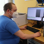 Mitarbeitender der Diakoneo-Werkstatt Rothenburg am Computer
